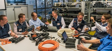 igus medewerkers zitten aan tafel met producten